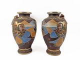 pair of decorative vases on a white background with a painting on them