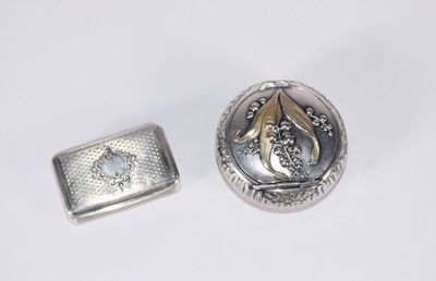 deux bijoux en argent et en or posés sur une surface blanche
