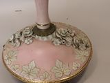 a pink vase with flowers on it sitting on a table