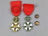 two medals and a star on a red ribbon on a gray surface