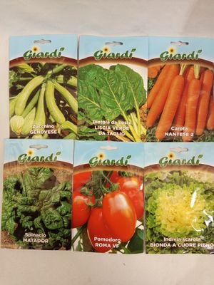 four seed packets of various vegetables on a white surface