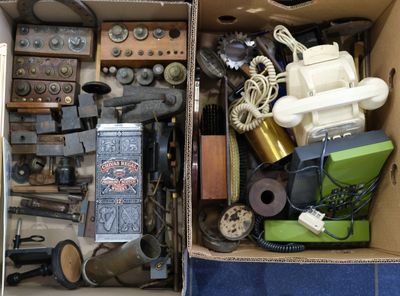 une boîte remplie d'objets hétéroclites posée sur le sol