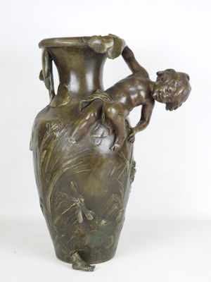 un vase en bronze sur lequel est représenté un enfant