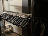 beaucoup de vêtements suspendus à une étagère dans une pièce