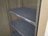 a small refrigerator with shelves in the corner of the room