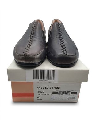 une paire de chaussures pour homme posée sur une boîte, avec un code-barres sur le côté
