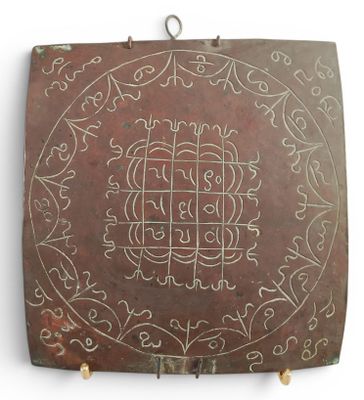a metal plaque with a design on it on a wall