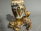 a vase with a lion on it on a table