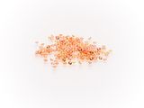a pile of gold colored beads on a white background