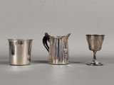 trois tasses en argent posées l'une à côté de l'autre sur une table