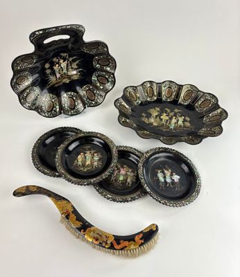 three pieces of black and gold decorated dishes and spoons