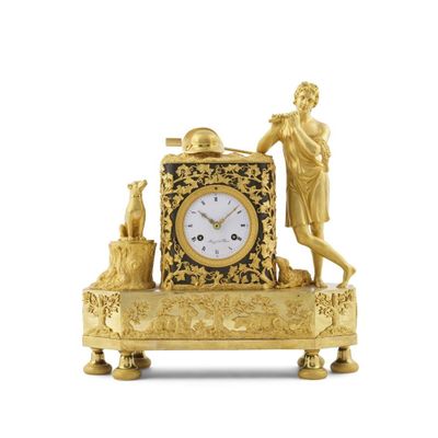 une horloge en or sur laquelle figurent un homme et un chien
