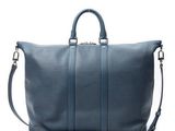 a large blue leather duffel bag on a white background