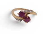 a close up of a gold ring with two ruby stones