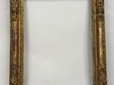un cadre photo doré sur un mur blanc avec un fond blanc