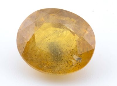 gros plan d'une pierre de saphir jaune sur une surface blanche