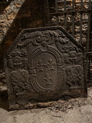 une pierre sur laquelle est gravé un visage, devant un portail