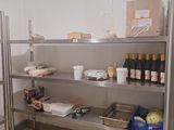 une étagère en métal sur laquelle sont posées des bouteilles de vin et d'autres produits alimentaires