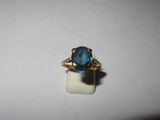 a close up of a ring with a blue stone in it