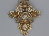 une croix en or et diamants sur laquelle est représenté un oiseau