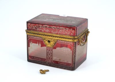 a red box with a gold lid and a gold bead on the bottom