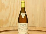 une bouteille de vin posée sur un tonneau en bois