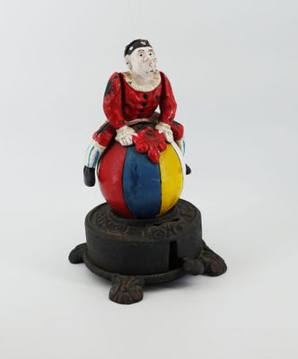 une figurine représentant un clown assis sur une balle