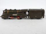 an old model train engine sitting on top of a white surface