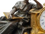 a statue of a woman sitting on a bench with a clock