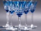 four blue wine glasses sitting on top of a table
