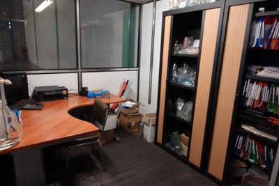 une pièce avec un bureau, une bibliothèque et un écran d'ordinateur