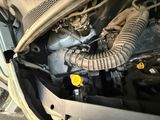 an image of a close up of a car ' s engine with a hose attached to it
