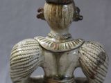 une figurine en céramique représentant une femme coiffée d'un chapeau