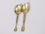 two spoons that are next to each other on a table