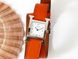a watch that is sitting next to a seashell
