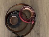 two belts that are laying on a wooden floor