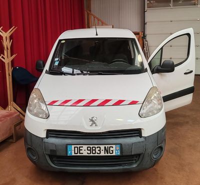 une camionnette blanche avec une bande rouge garée dans un garage