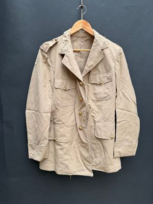 une photo d'une veste suspendue à un mur à l'aide d'un cintre en bois