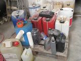 a pile of gas cans sitting on a pallet in a garage