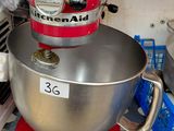 a red mixer sitting on top of a kitchen counter
