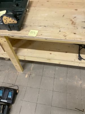 un établi sur lequel sont posés des outils, dans une pièce