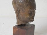 statue of a head on a wooden block on a white background