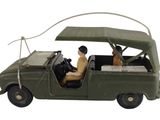 une figurine représentant un homme et un chien assis dans une voiture