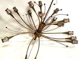 a metal sculpture of a bunch of flowers on a white surface