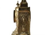 a gold clock sitting on a stand with a bird on top