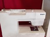 a white sewing machine sitting on a red cloth