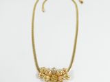 an image of a gold necklace with flowers on it