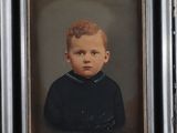 portrait d'un jeune garçon en chemise noire, dans un cadre noir