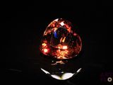 gros plan d'un diamant orange sur une surface noire