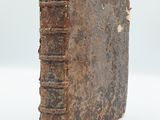 an old book sitting on top of a white surface